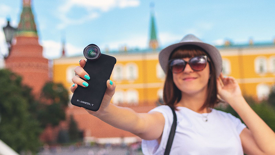 Touristin macht ein Selfie von sich vor einem historischen Gebäude.