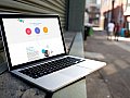 Ein aufgeklappter Laptop zeigt die alte Webcare Webseite.