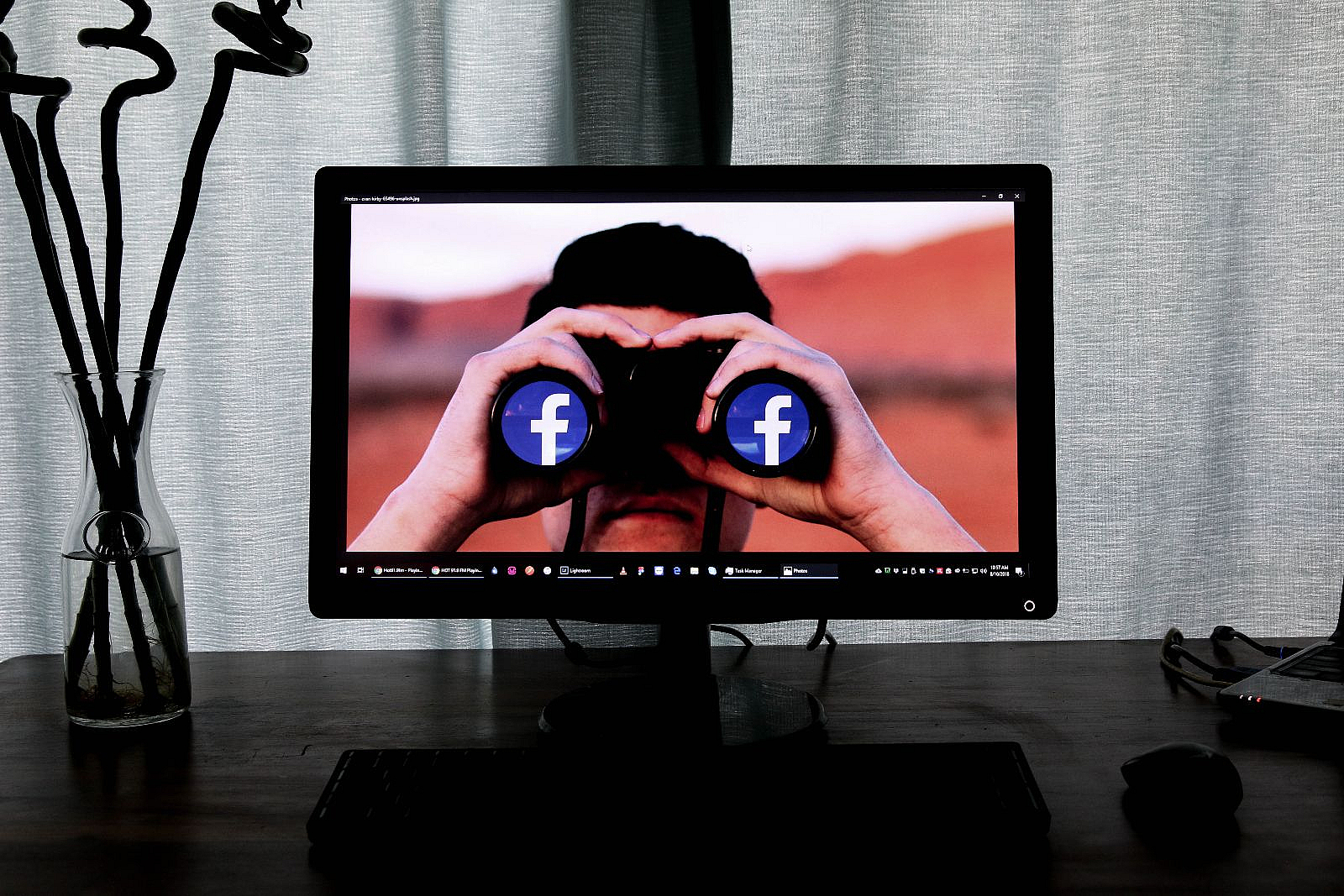 Person guckt durch Fernglas mit Facebook Logos