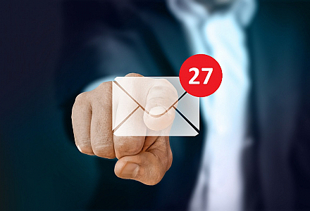 Finger tippt auf E-Mail-Symbol mit 27 neuen Nachrichten