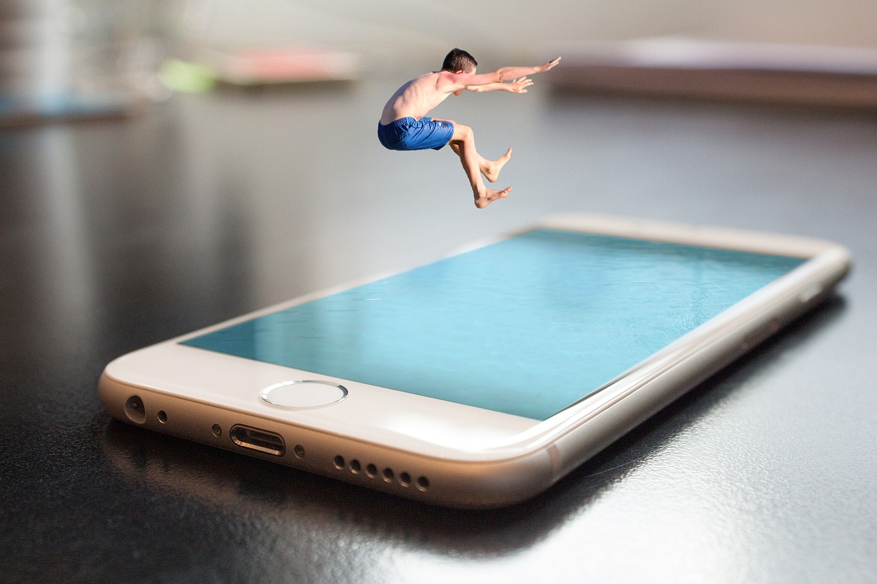Eine Person hüpft in ein riesen Smartphone, das aussieht wie ein Swimmingpool.