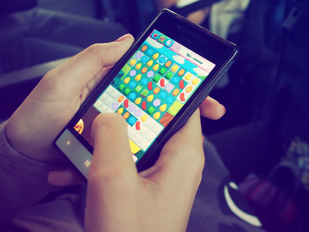 Auf einem Smartphone wird das Spiel Candy Crush gespielt, das mobile Game lässt sich auch leicht während der Arbeitszeit spielen