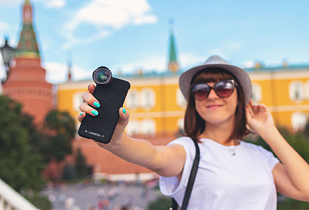 Touristin macht ein Selfie von sich vor einem historischen Gebäude.