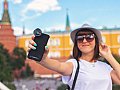 Touristin macht ein Selfie von sich vor einem historischen Gebäude.