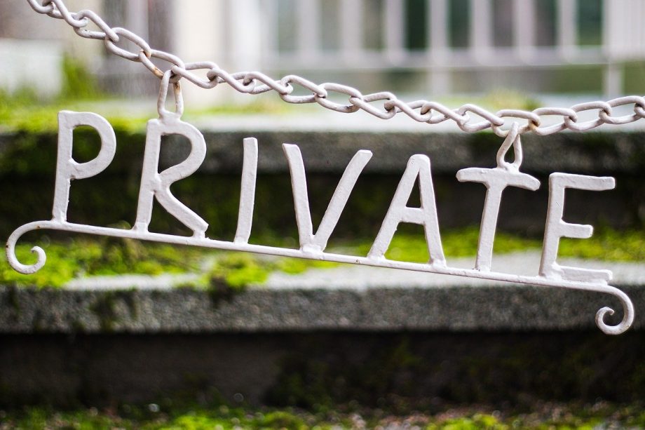 Buchstaben aus Metall ergeben das englische Wort "private" und hängen an einem Durchgang