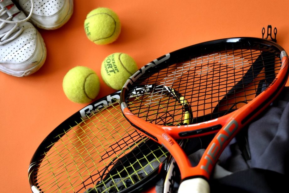 Tennisschläger, tennisbälle und Turnschuhe