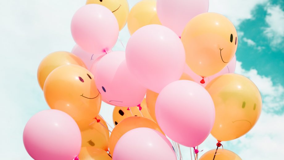 Luftballons mit fröhlichen und traurigen Smileys drauf