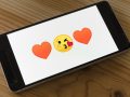 Smartphone mit Kuss- und Herz-Emojis