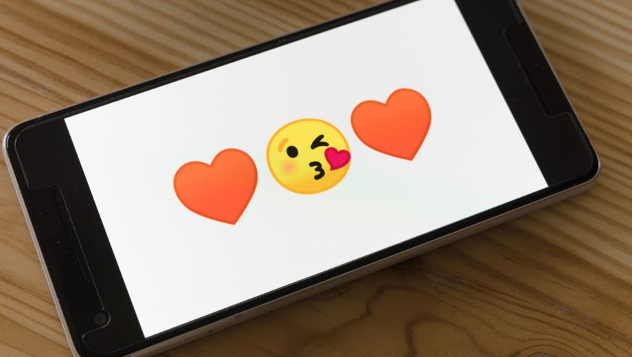 Smartphone mit Kuss- und Herz-Emojis