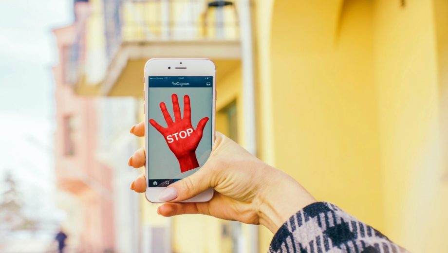 Rote Hand und das Wort Stop auf einem Smartphone-Bildschirm