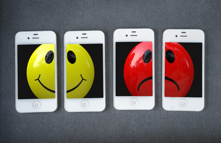 Fröhliches und trauriges Smiley auf Smartphone-Bildschirmen
